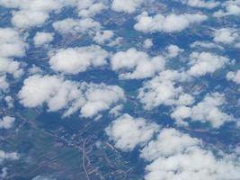 Luftaufnahme der Wolkenlandschaft durch das Flugzeugfenster gesehen foto