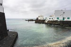 lanzarote, spanien-august 7,2018-blick auf die kleine stadt punta mujeres auf der insel lanzarote, berühmt für ihre natürlichen schwimmbäder an einem bewölkten tag foto