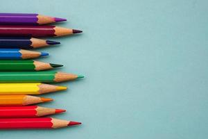 Draufsicht auf Buntstifte oder Pastell auf blauem Hintergrund. Lern-, Lern- und Präsentationskonzept.