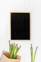 frischer grüner Spargel mit schwarzem Tafelrahmen foto