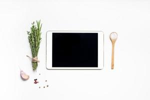 leerer tablet-pc mit grünen kräutern und gewürzen foto
