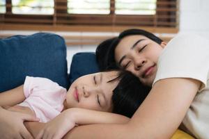 asiatische familienmutter und tochter schlafen auf dem sofa foto