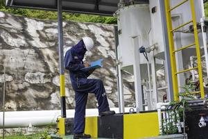 männliche arbeiter inspektion visuelle rohrleitung öl- und gaskorrosionsrohr dampfleitung foto