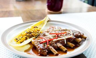 Schweinerippchen auf weißem Teller im Restaurant foto