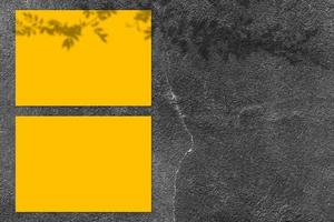leeres gelbes quadratisches plakatmodell mit hellem schatten auf schwarzem betonwandhintergrund. foto