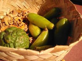 eine Vielzahl von Gewürzen zum Kochen, serviert in einem geflochtenen Bambusbehälter, wie Kurkuma, Ingwer, Bilimbi und Limette. foto