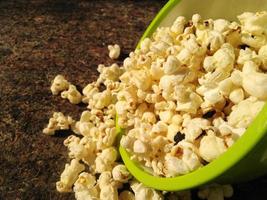 Hoher Blick auf reifes Popcorn, serviert in grüner Schale. Nahaufnahme. Neben der Gewichtsabnahme hat der Verzehr von Popcorn auch andere gesundheitliche Vorteile. foto