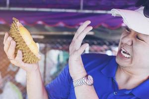 mann, der durian ekelhaften ausdruck macht foto