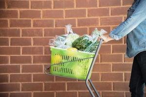 dame kauft frisches gemüse im supermarkt ein - frau im frischmarkt-lifestyle-konzept foto