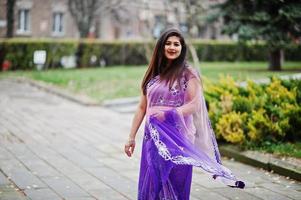 indisches hinduistisches Mädchen im traditionellen violetten Saree posierte auf der Herbststraße. foto