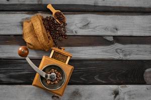 vintage kaffeemühle. alte retro handbetriebene kaffeemühle aus holz und metall. manuelle kaffeemühle zum mahlen von kaffeebohnen. auf dem alten hölzernen Hintergrund. foto