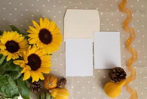 herbstsonnenblumenarrangement, komposition mit leerer karte, dekorativer kürbis, orangefarbene transparente lockige bandschablone für danksagung und herbstferien, konzeptionelle flache draufsicht foto