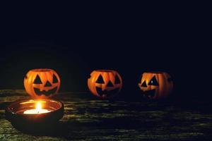 Kerzen und Halloween-Kürbisse werden auf Holzböden platziert.