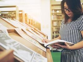 Frau liest Buch in der Bibliothek foto