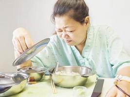 Eine Patientin ist langweiliges Essen in einem Krankenhaus foto