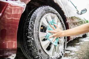 mann wäscht auto mit shampoo - alltagsautopflegekonzept foto