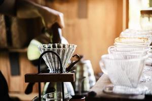 Mann, der frischen Kaffee im Vintage-Café mit grünem Naturhintergrund macht - Menschen mit frischem Kaffee im Naturkonzept foto