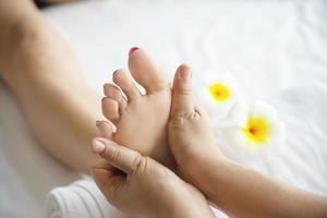 frau, die fußmassageservice von masseurin erhält, nah an hand und fuß - entspannen sie sich im fußmassagetherapie-servicekonzept