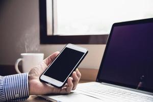 geschäftsmann, der mit computer mit kaffeetasse im hotelzimmer arbeitet - leute, die lebensstilkonzept arbeiten foto