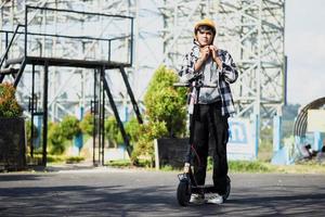 asiatischer mann, der sich fertig macht, indem er einen schutzhelm trägt, bevor er einen elektroroller fährt. modernes und ökologisches Verkehrskonzept. foto