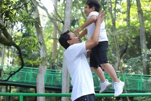 glücklicher asiatischer vater und sohn, die draußen spielen und spaß haben. Familien-, Kindheits- und Vaterschaftskonzept foto