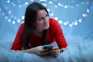 Mädchen mit einem Telefon in ihren Händen auf Bokeh-Hintergrund foto