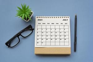 Juli 2023 Tischkalender auf blauem Hintergrund. direkt darüber. foto