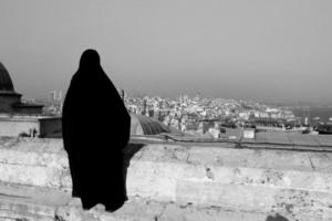 muslimische verschleierte frau, die das stadtbild von istanbul beobachtet foto