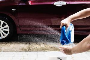 mann bereiten shampoowasser zum waschen des autos vor - hausmenschen auto sauberes konzept foto