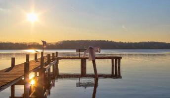 schöner und romantischer sonnenuntergang an einem see in gelben und orangefarbenen farben foto