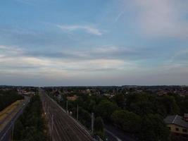 Luftaufnahmen Hochwinkelansicht der Stadt Luton in England und des Bahnhofs und des Zuges auf Gleisen bei Sonnenuntergang foto