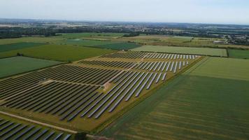 Luftaufnahmen aus der Vogelperspektive von grünen Energiequellen aus natürlichen Generatoren von Windkraftanlagen und Sonnenkollektoren in England, Großbritannien foto