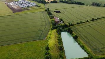 Luftaufnahmen aus der Vogelperspektive von grünen Energiequellen aus natürlichen Generatoren von Windkraftanlagen und Sonnenkollektoren in England, Großbritannien foto