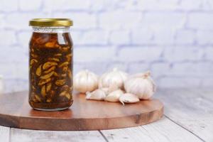 hausgemachte Knoblauchgurke in einem Glas auf dem Tisch, foto