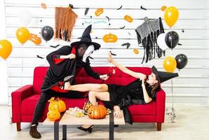 fröhliches Halloween-Party-Konzept. junger mann und frau, die als vampire, hexe oder geist tragen, feiern das halloween-fest foto