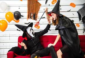 fröhliches Halloween-Party-Konzept. junger mann und frau, die als vampire, hexe oder geist tragen, feiern das halloween-fest foto