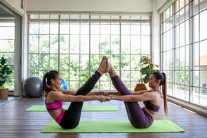 junge asiatische frau, die zu hause yoga trainiert und macht, gesundes konzept. foto