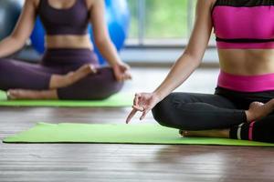 junge asiatische frau, die zu hause yoga im lotussitz trainiert und macht, gesundes konzept. foto