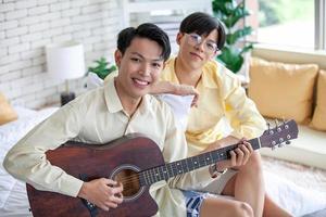 Asain schwules Paar, das zusammen zu Hause Gitarre spielt, lgbtq-Konzept. foto