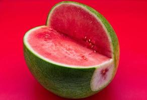 frische Wassermelone isoliert auf rotem Hintergrund. frisches Sommerobst. foto