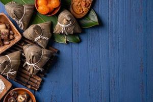 zongzi - drachenbootfestivalkonzept reisknödel, traditionelles chinesisches essen auf blauem holzhintergrund für duanwu festival, draufsicht, flaches lagdesignkonzept. foto