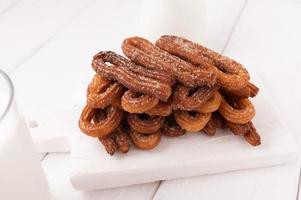 Hausgemachte Churros auf weißem Holzhintergrund. foto