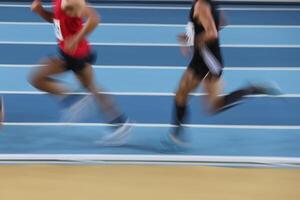 Verschwommene Athleten laufen in der Leichtathletik foto