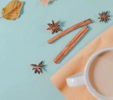 Herbstkomposition. tasse kaffee, herbstblätter, zimtstangen und anissterne auf hellblauem pastellhintergrund. flache Lage, Kopierraum von oben. foto