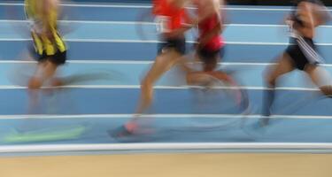 Verschwommene Athleten laufen in der Leichtathletik foto