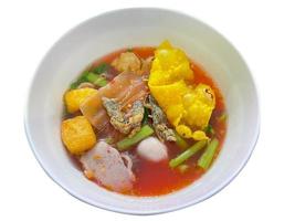 thailändische traditionelle rote tofu-saucennudeln, serviert mit fischbällchen, gebratenem tofu und anderem. ein beliebtes leckeres Street Food der Thailänder. asiatisches Essen. von oben geschossen. isoliert auf weißem Hintergrund. foto