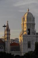 die untergehende sonne wirft goldenes licht auf die kirche von santa maria in lissabon, portugal foto