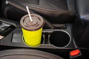 kaffee- oder teebecher grün auf der fahrzeugkonsole im modernen luxusautoinnenraum platziert foto