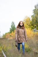 Porträt einer jungen süßen Frau im Herbstpark. schönes kaukasisches Mädchen, das im Wald spazieren geht foto