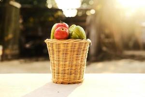 frische Tomaten und Kürbis in einem Korb aus Bambusblättern. foto